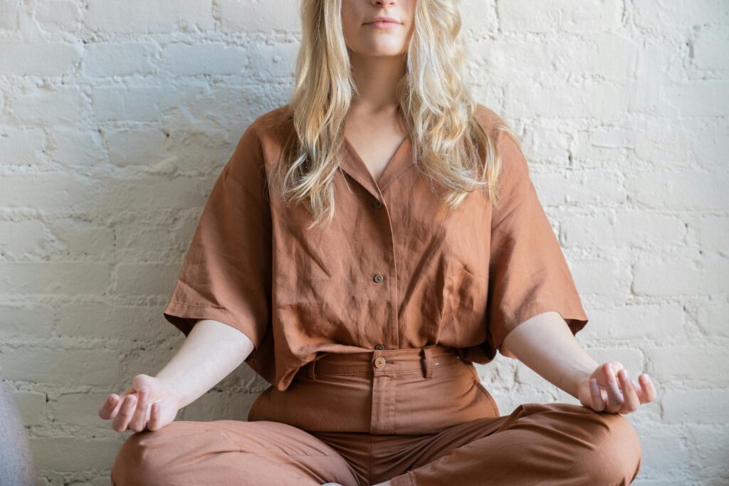 Woman meditating indoors, practicing mindfulness and relaxation techniques.